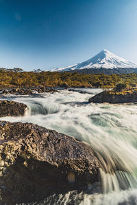 Scenic view of waterfall against sky