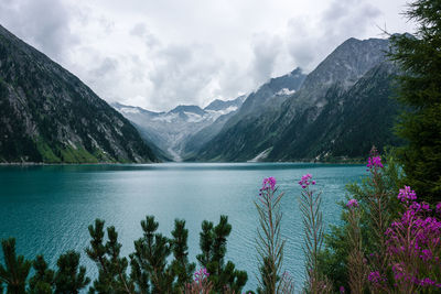 Scenic view of lake by mountains against sky