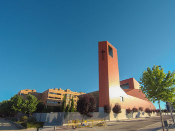 Outside view of a modern church with its high bell tower on a sunny afternooon with blue sky