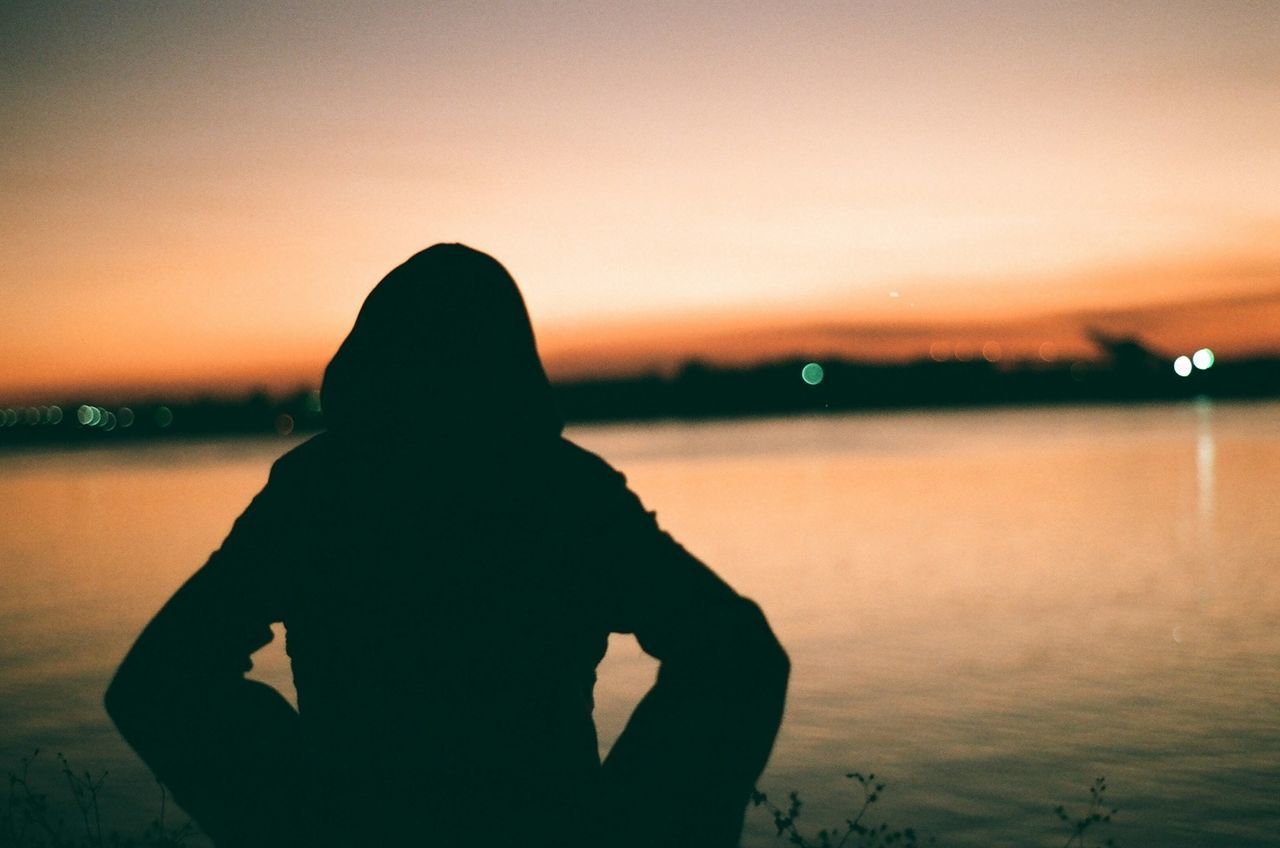 sunset, silhouette, lifestyles, leisure activity, water, standing, men, rear view, sky, waist up, sea, tranquility, person, three quarter length, tranquil scene, scenics, beauty in nature, dusk