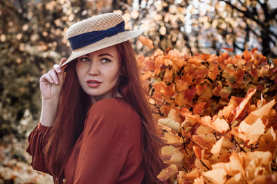 Woman wearing hat looking away during autumn