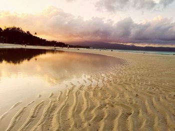 Scenic view of beach against cloudy sky