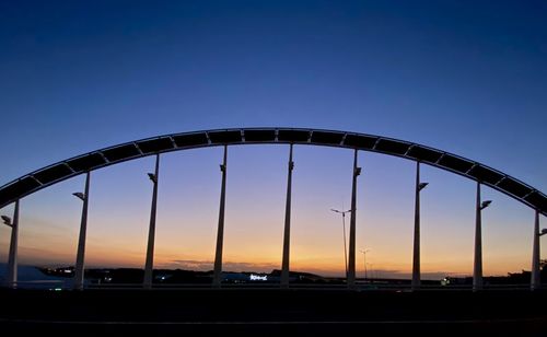 Low angle view of bridge against sky at sunset
