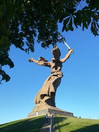 Low angle view of statue against blue sky