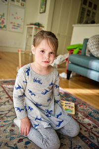 Portrait of boy sitting on floor