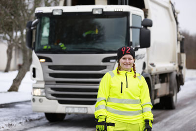 Woman standing in front of garbage truck