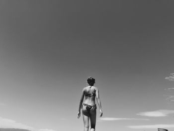 Rear view of a woman standing against sky