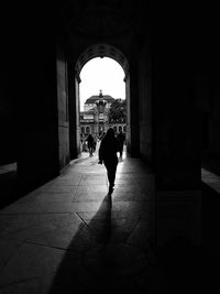 Rear view of silhouette woman walking in corridor of building