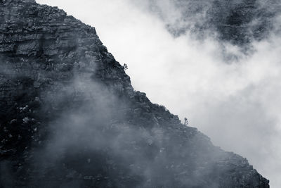 Low angle view of rocky mountain against sky