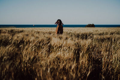 Rear view of woman standing amidst plants