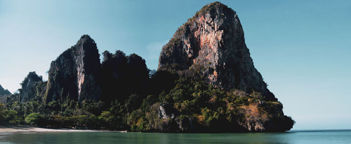 Rock formations in sea against clear sky