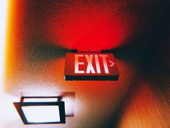 Low angle view of illuminated sign on wall