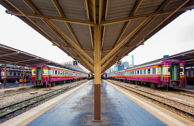 Railway station platform with metal platform roof where passenger trains are parked