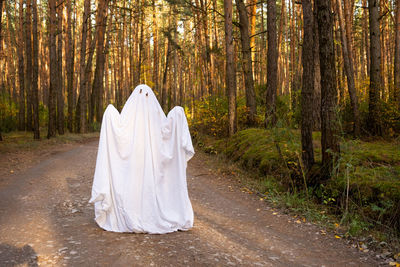 Rear view of woman standing in forest