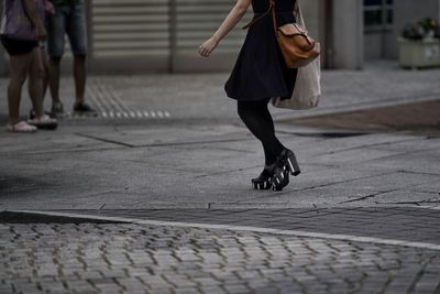 Low section of woman walking in city