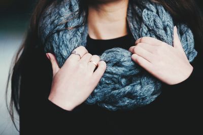 Midsection of woman adjusting scarf