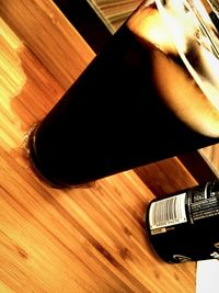 Low section of person standing on wooden floor