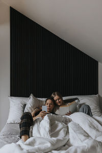 View of homosexual couple relaxing in bed together