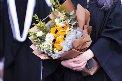 Midsection of woman holding flower bouquet