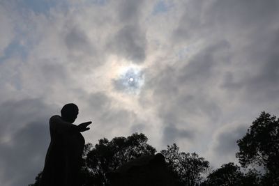 Low angle view of silhouette man against cloudy sky