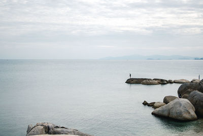 Scenic view of rocks in sea against sky