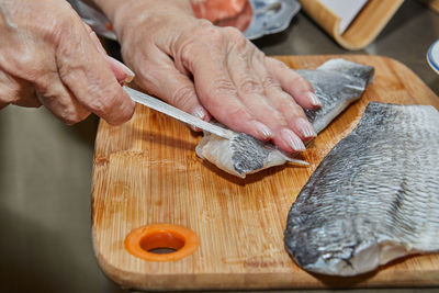 Chef is skinning salmon fillets for cooking