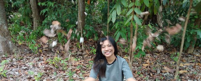 Portrait of smiling young woman lying on land