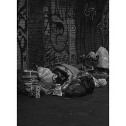 People sleeping on street against wall