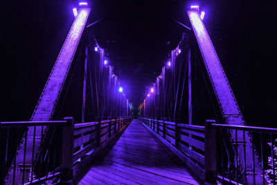 Illuminated bridge against sky at night