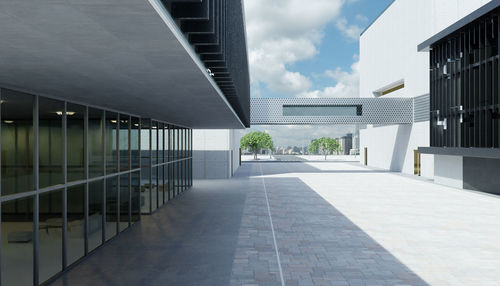 Footpath by swimming pool in building against sky