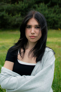 Portrait of young woman standing on field