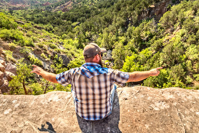 Man sitting on the edge of a cliff, palo duro canyin state park, texas