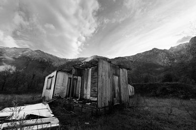 Old building by mountains against sky