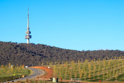 View of tower on landscape against blue sky