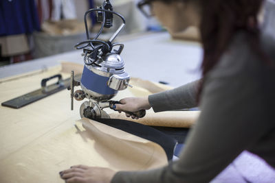 Seamstress cutting cloth in factory