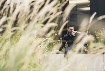 Businessman sitting outside, taking a break, drinking coffee