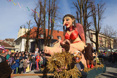 Statue of people at music concert against sky