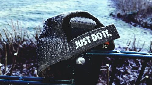 Close-up of text on metal at beach