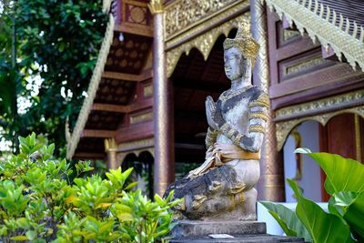 Statue outside temple against building