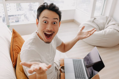 Portrait of smiling man gesturing at home