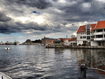 Buildings in city against cloudy sky