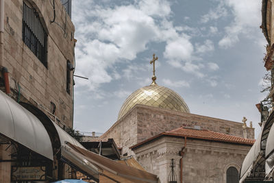 Low angle view of buildings and dome against sky in city