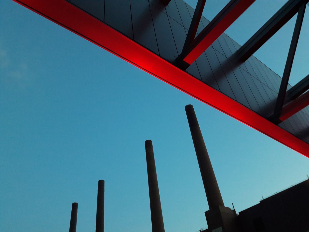 low angle view, sky, architecture, built structure, no people, clear sky, blue, nature, day, building exterior, red, metal, outdoors, tall - high, pattern, copy space, building, sunlight, close-up, roof, girder, directly below