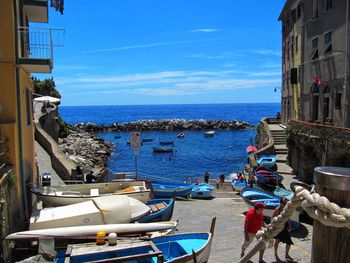 Boats moored on sea against buildings