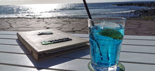 Close-up of drink on table at beach