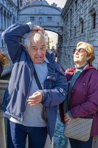 Portrait of smiling friends standing in city