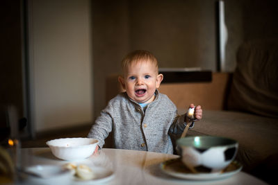 Portrait of cute boy having food at home