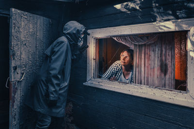 Fictional movie poster. people with flashlights, masks and protective clothing inspect old house. 