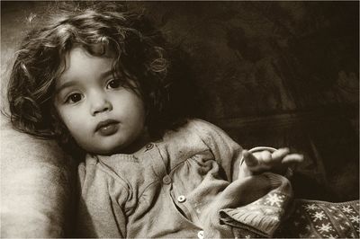 Close-up portrait of cute girl relaxing on sofa at home