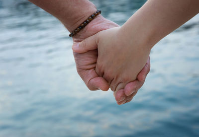 Cropped image of couple holding hands